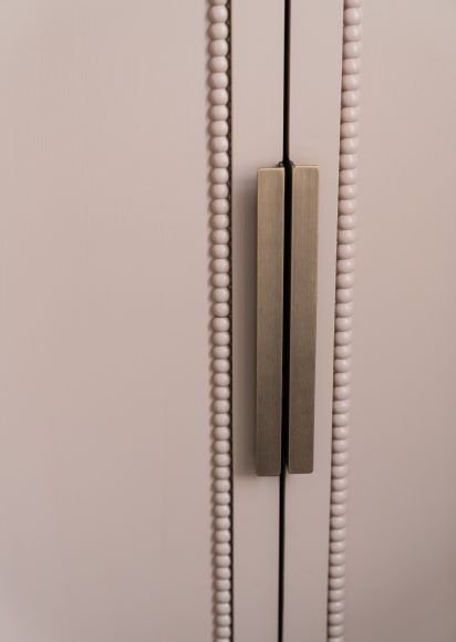 Close-up gouden handgreep op kastenwand met Decwood mouldings detail, maatwerk badkamer atelier Det Wageningen