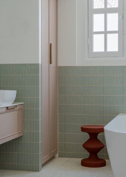 Badkamer detail met maatwerk kastenwand, groene verticale tegels van Designtegels, terrazzo vloeren en terracotta kruk, interieurontwerp atelier Det Wageningen