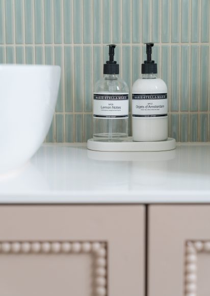 Badkamer styling detail met Marie-Stella-Maris handzeep en lotion op Dekton werkblad, groene verticale wandtegels, interieurontwerp atelier Det Wageningen
