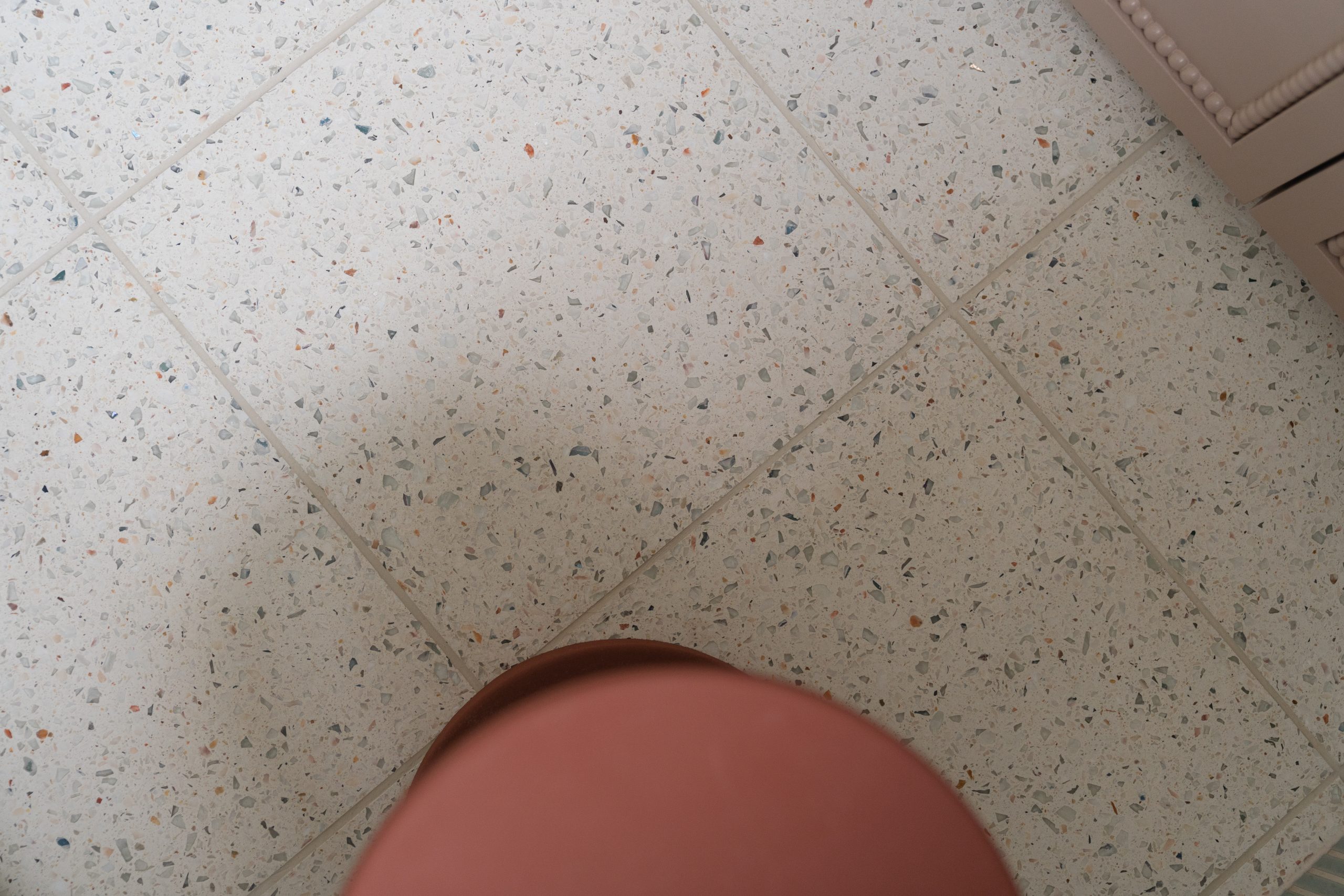 Terrazzo vloer van Designtegels met terracotta kruk detail, duurzaam materiaal badkamerontwerp atelier Det Wageningen