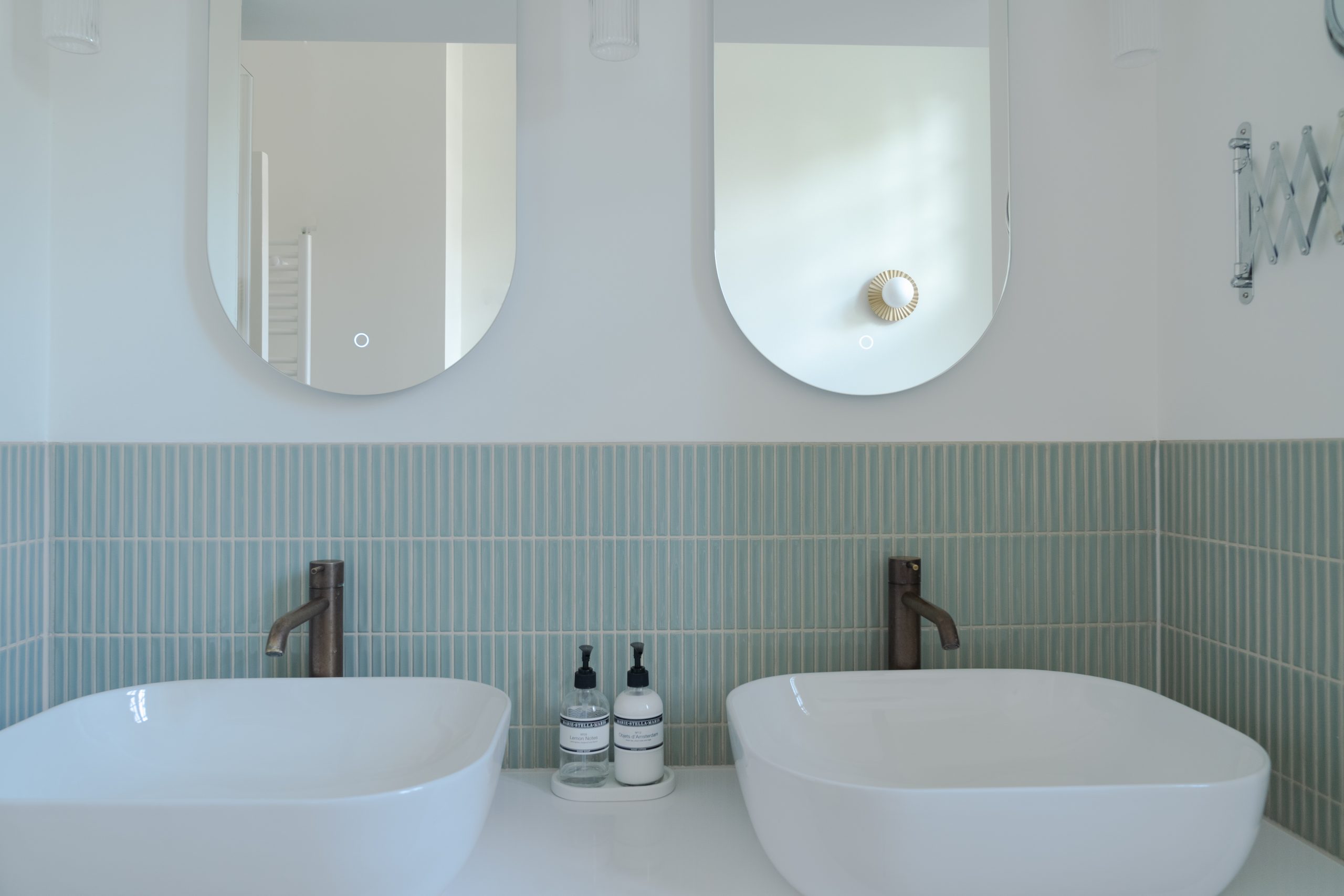 Dubbele wastafel met ronde spiegels, Hotbath bronzen wandkranen, groene vertical tegels en Dekton werkblad, badkamerontwerp atelier Det Wageningen