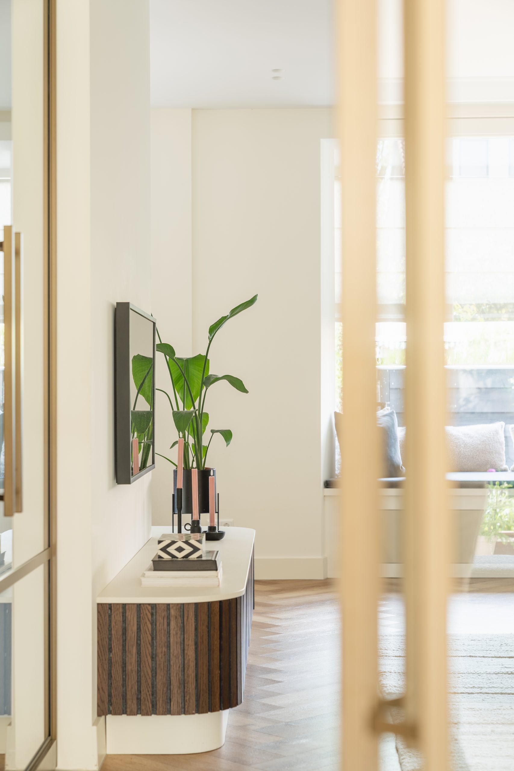 Interieur hoekhuis Rotterdam - doorkijkje hal naar woonkamer met maatwerk tv-meubel en bronzen aluminium schuifdeur