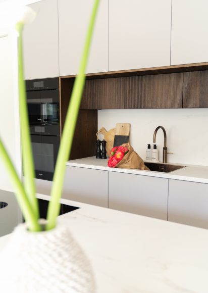 Keukenontwerp hoekhuis Rotterdam met houten lamellen detail en Dekton werkblad